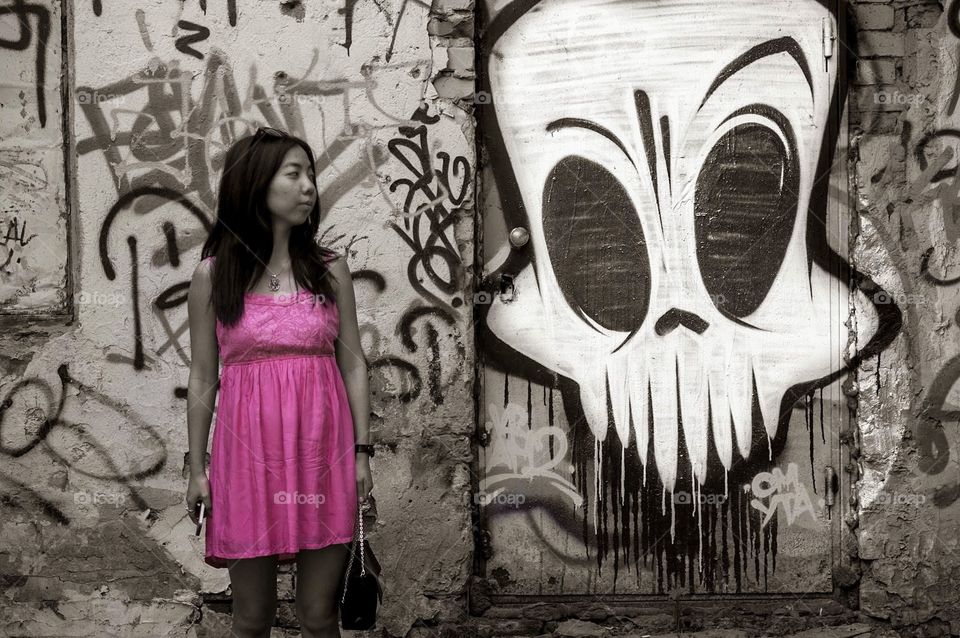 Woman standing in front graffiti wall