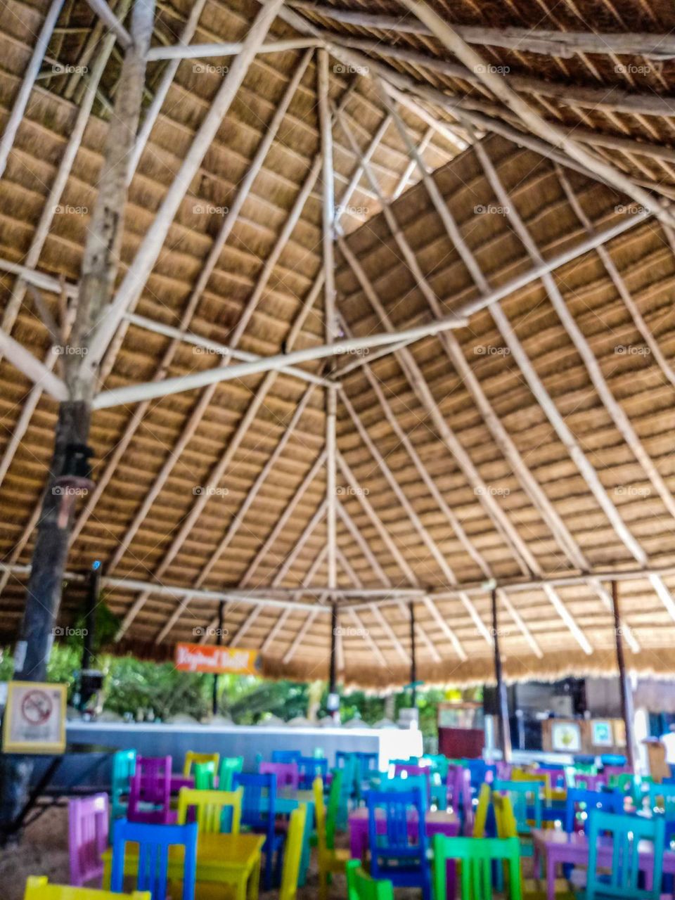 The inside of a hut with colorful plastic chairs 