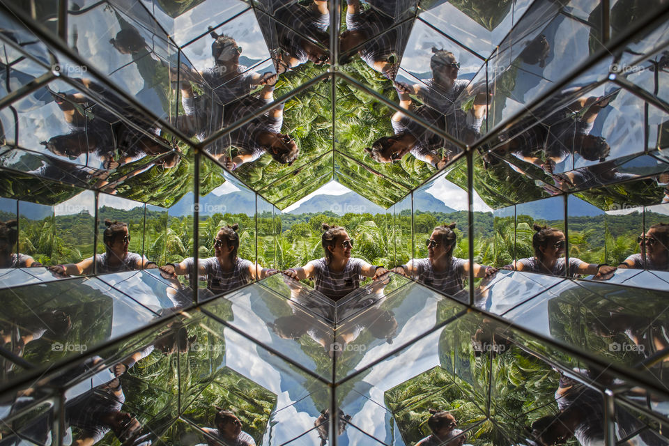 Girl with image reflected inside kaleidoscope