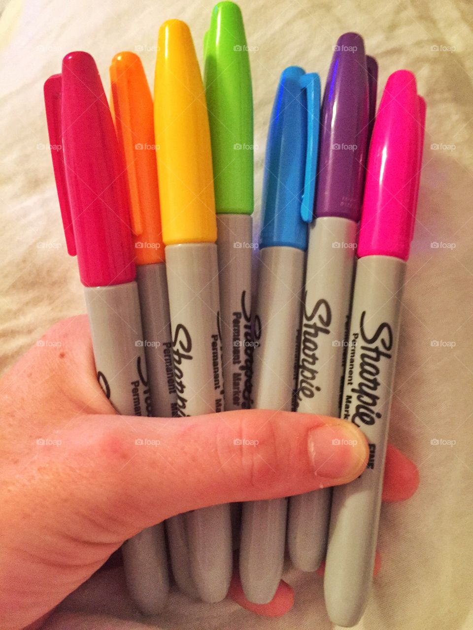 Rainbow of sharpies . A hand holding sharpies 