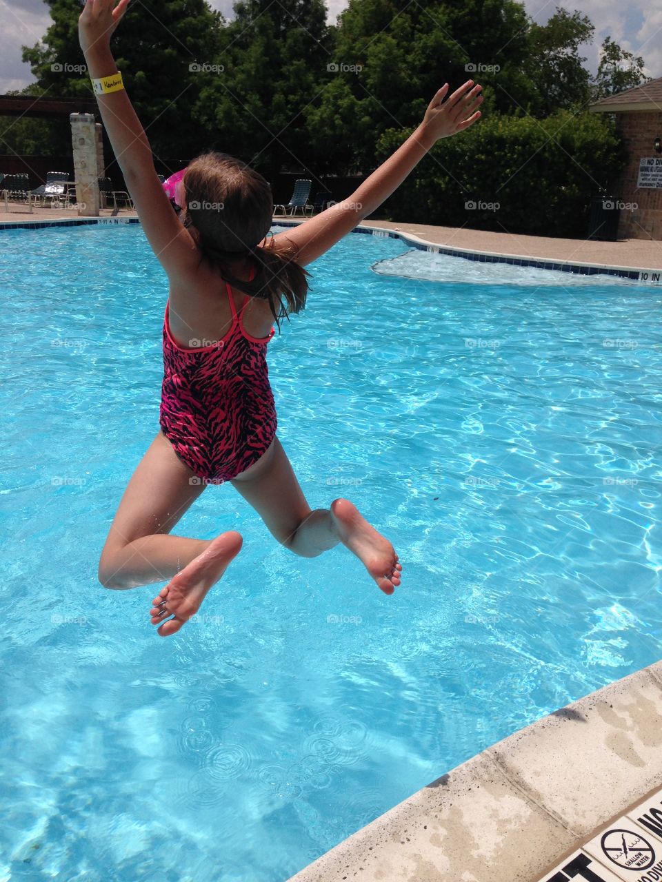 Jump in. Girl jumping into the pool