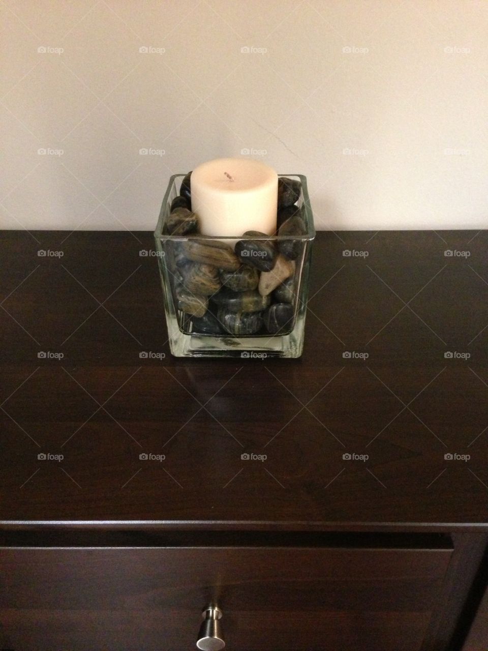 Candle in vase with rocks