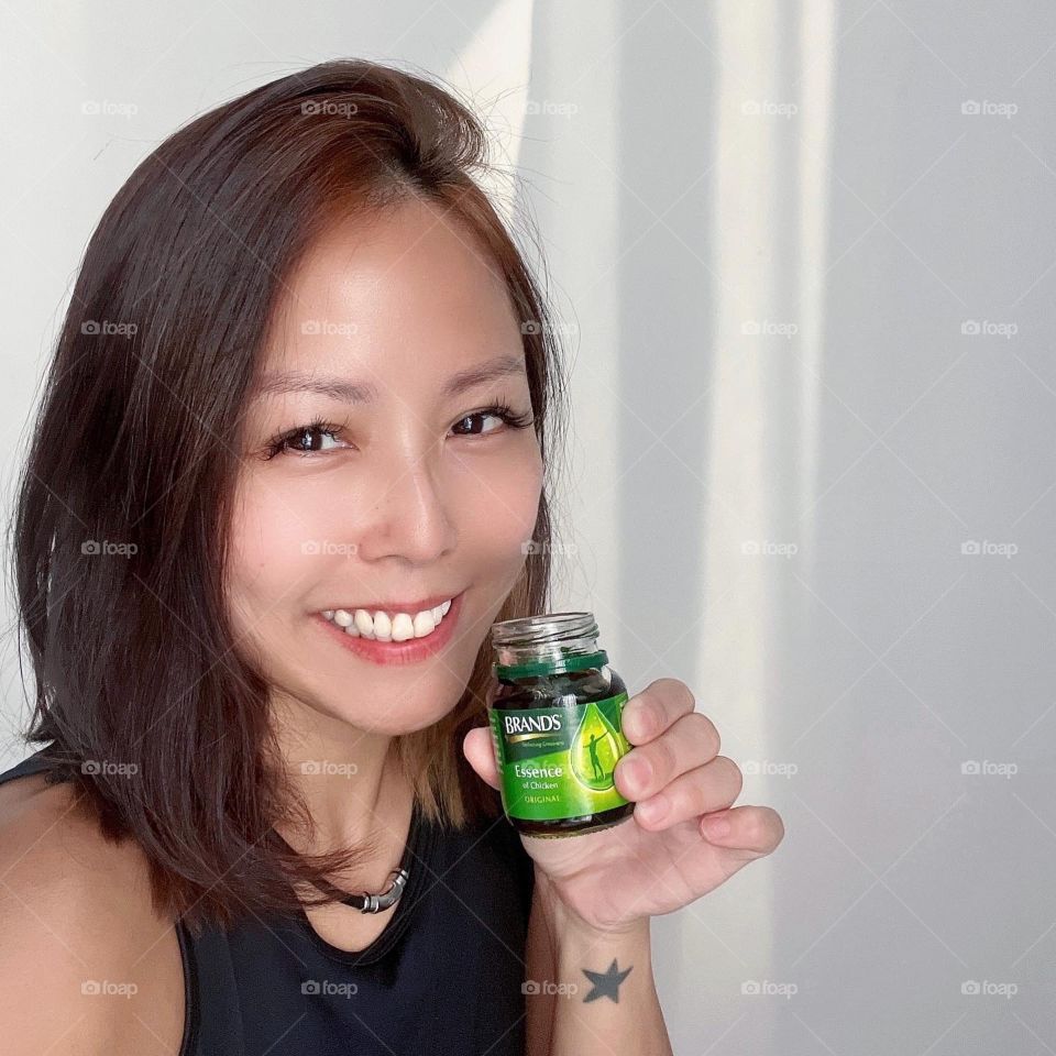 Asian woman in Chicken essence for energy of the day 