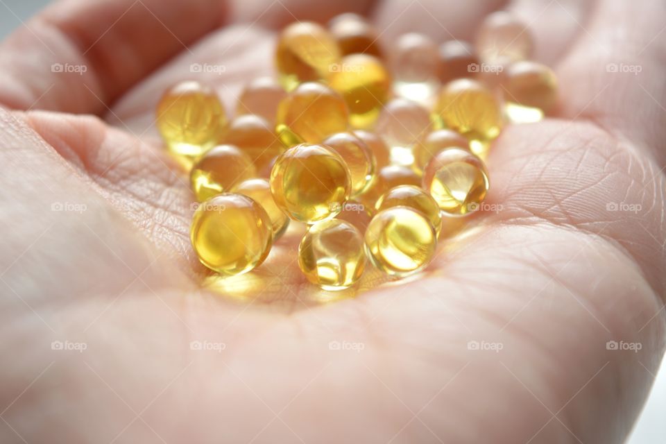 vitamins capsules in the hand close up background beautiful texture muted colors