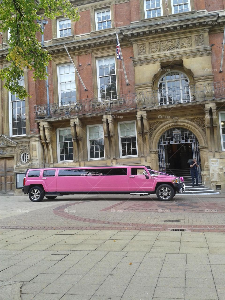 Pink lemo waiting a bride in front of a church