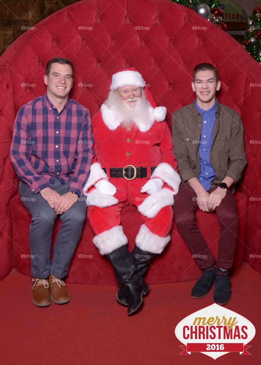 Family Christmas photo of two well dressed brothers and Santa. 