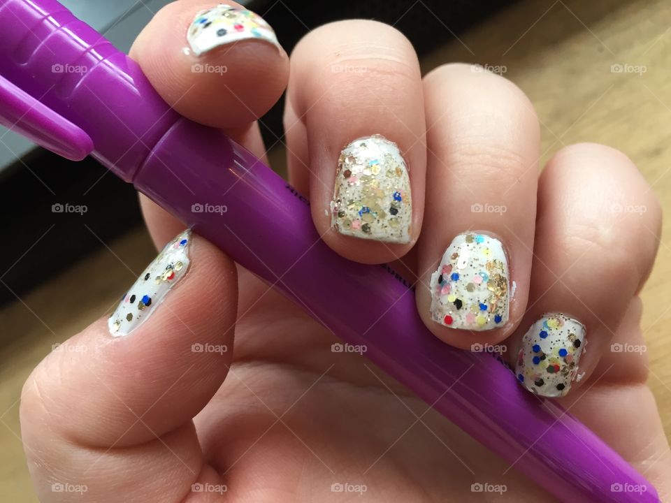 Glitter nail art holding purple highlighter