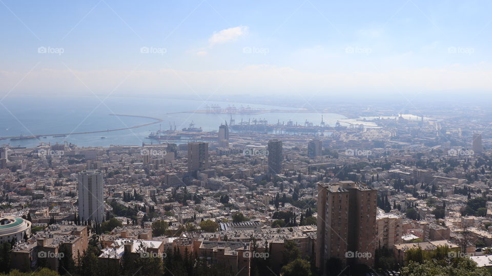 Blue sky with white clouds and a city and a port and blue sea