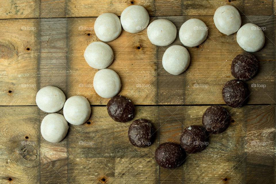 sweet, chocolate gingerbreads in shape of hearth on a rustic background