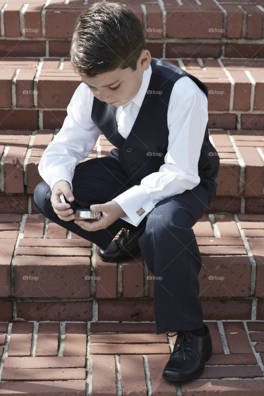 Boy in a waistcoat sitting on steps