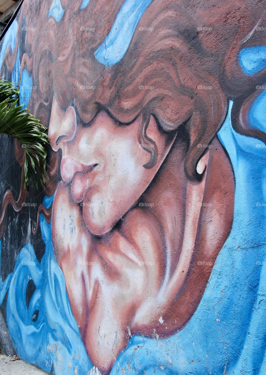 Mural en la comuna 13 de Medellín, con la inclusión de la Palmera da la sensación de que el retrato hecho está interactuando con ella 