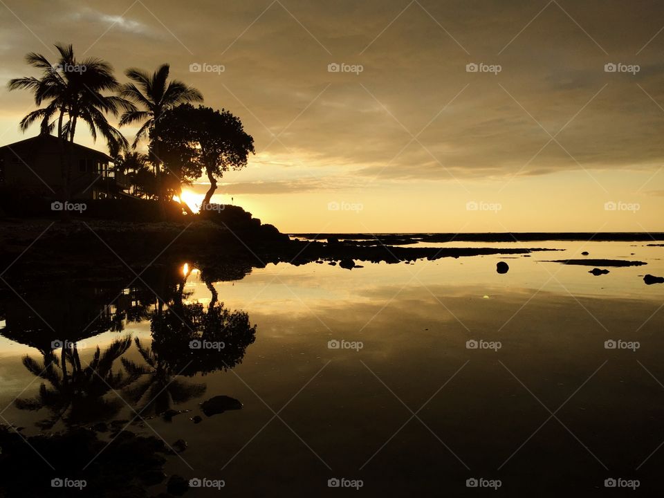 A perfect mirror image reflected upon calm waters of Puako Beach, Hawaii. 