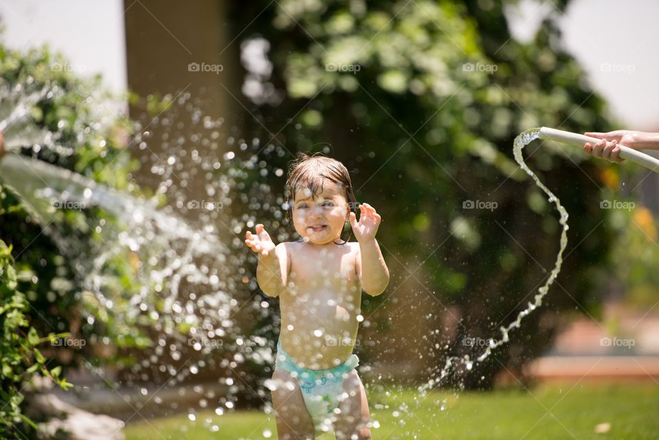 baby girl playing in the water splash