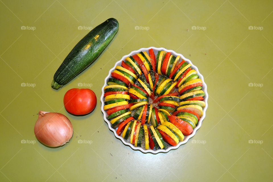 Sliced vegetables arranged in a white bowl