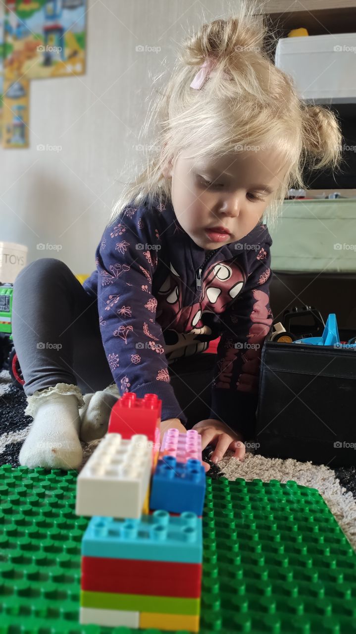 little Girl Playing with lego duplo