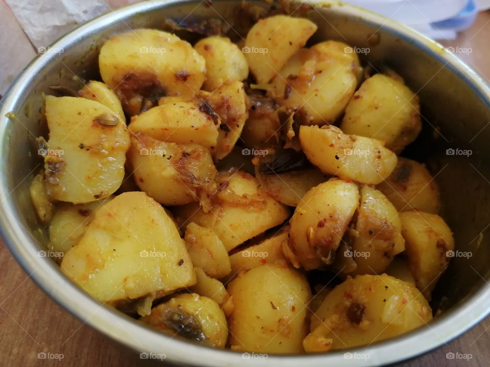 BOWL OF TASTY BOILED POTATO or Aloo Masala AND INGRIDENTS WITH SALT, SPICE, CHILLI, TURMERIC, CUMIN, BLACK PAPER.