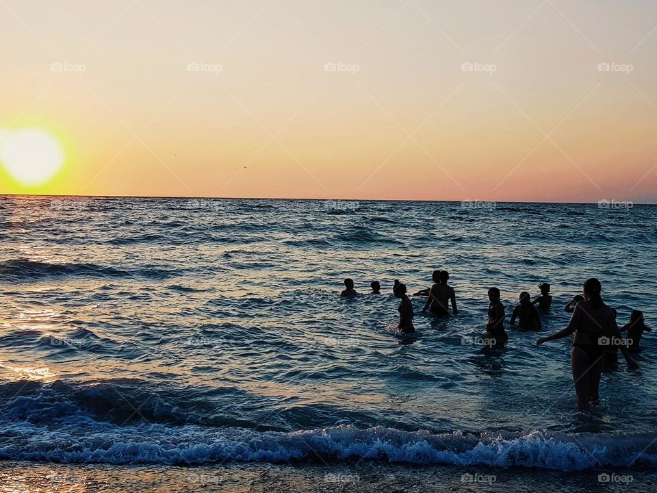 the crowds of people in the sea at sunrise