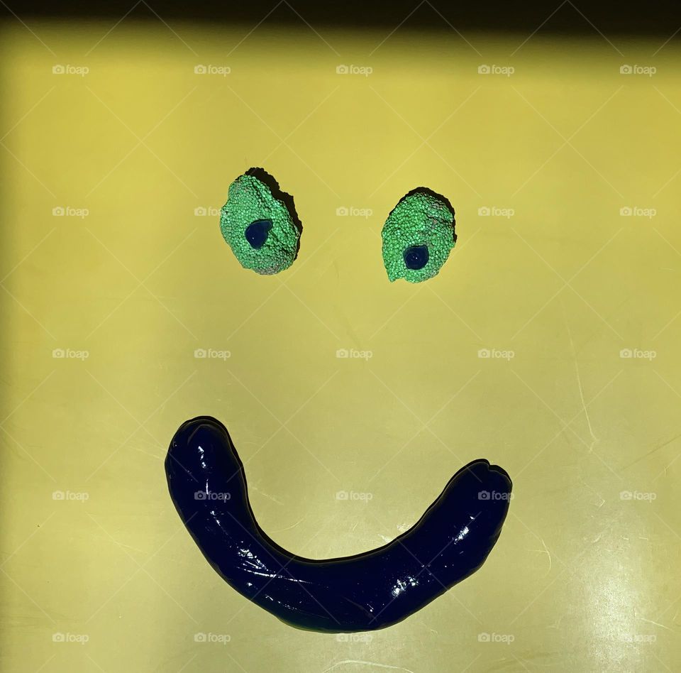 Slime Face With The Emotion That Reads As Really Happy On Yellow Background With Light And Shadow.