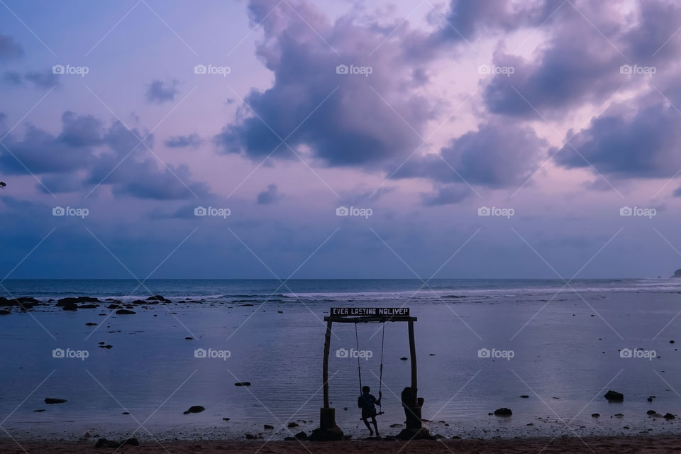 Twilight starts to sink, evening becomes night. Savoring the beautiful atmosphere of nature from a beach swing.