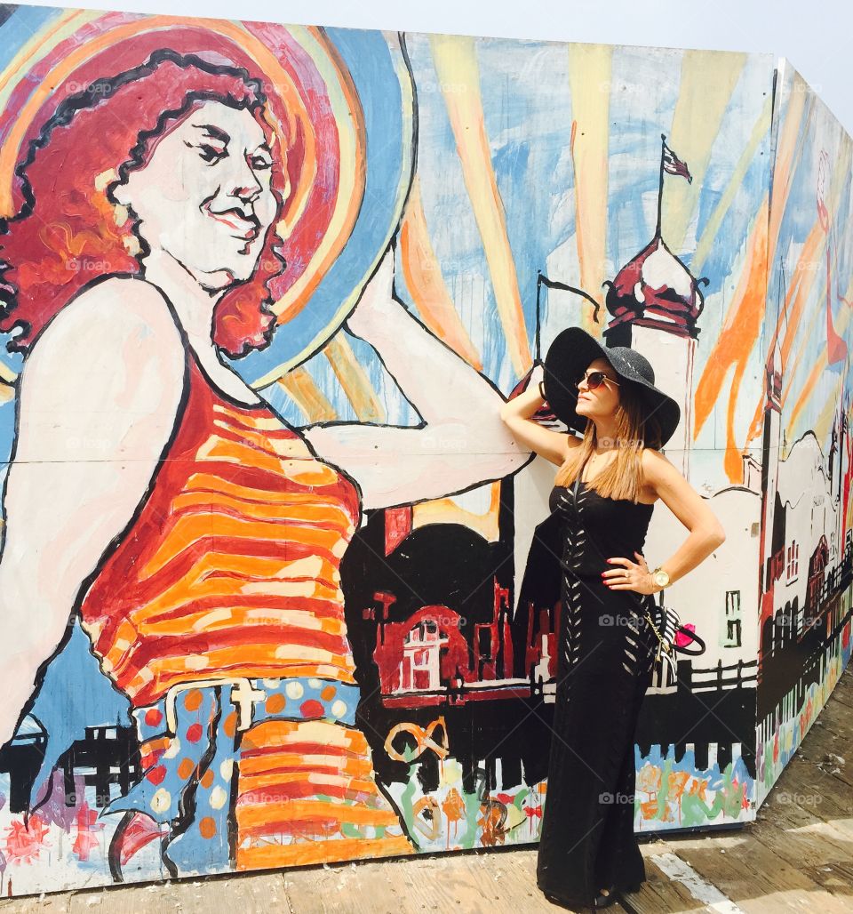 Stylish woman posing near the graffiti wall