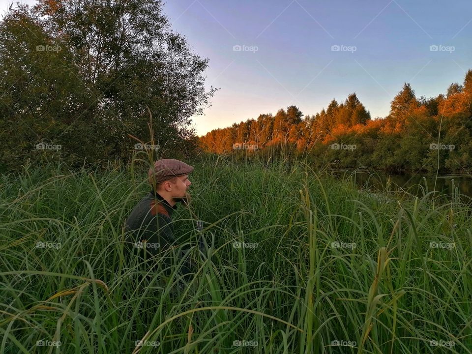A man on a duck hunt in Lapland, Finland. Just have to wait for the birds evening flight hidden.