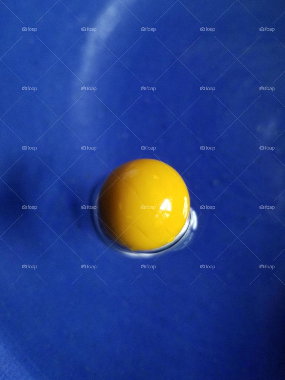 Yellow Marble in a Blue Bowl of Water