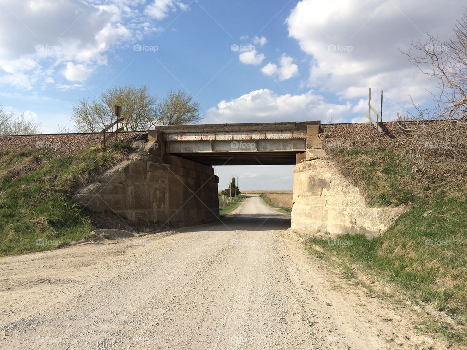 Railroad overpass crossing rural Iowa gravel road