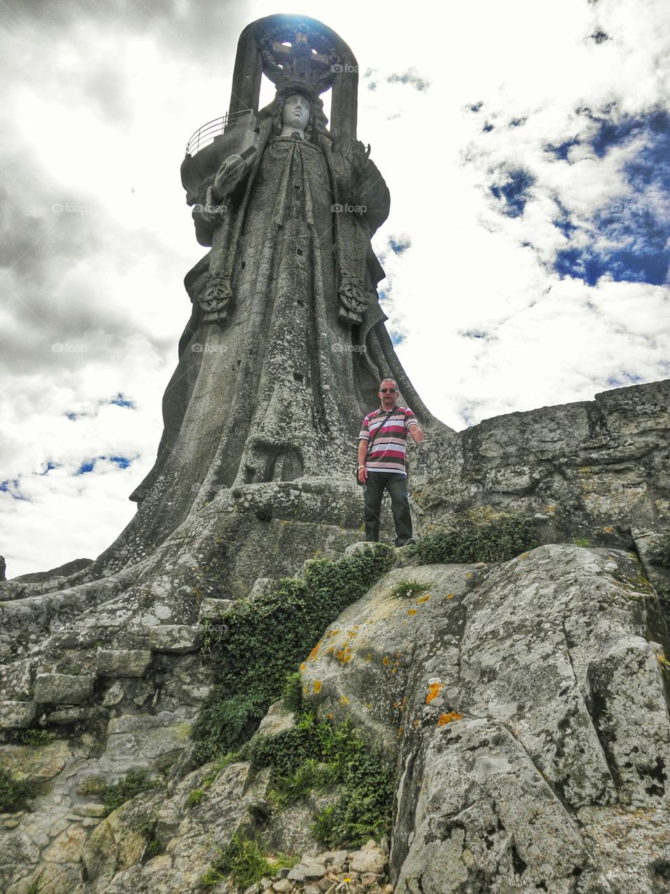 Man standing on staircase in front of statue