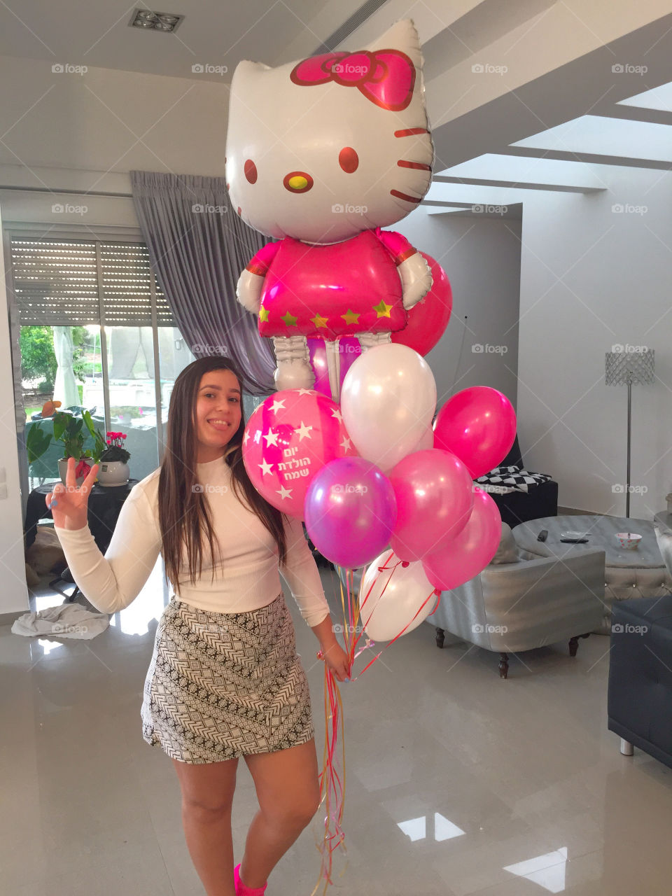 Girl with balloon showing peace sign