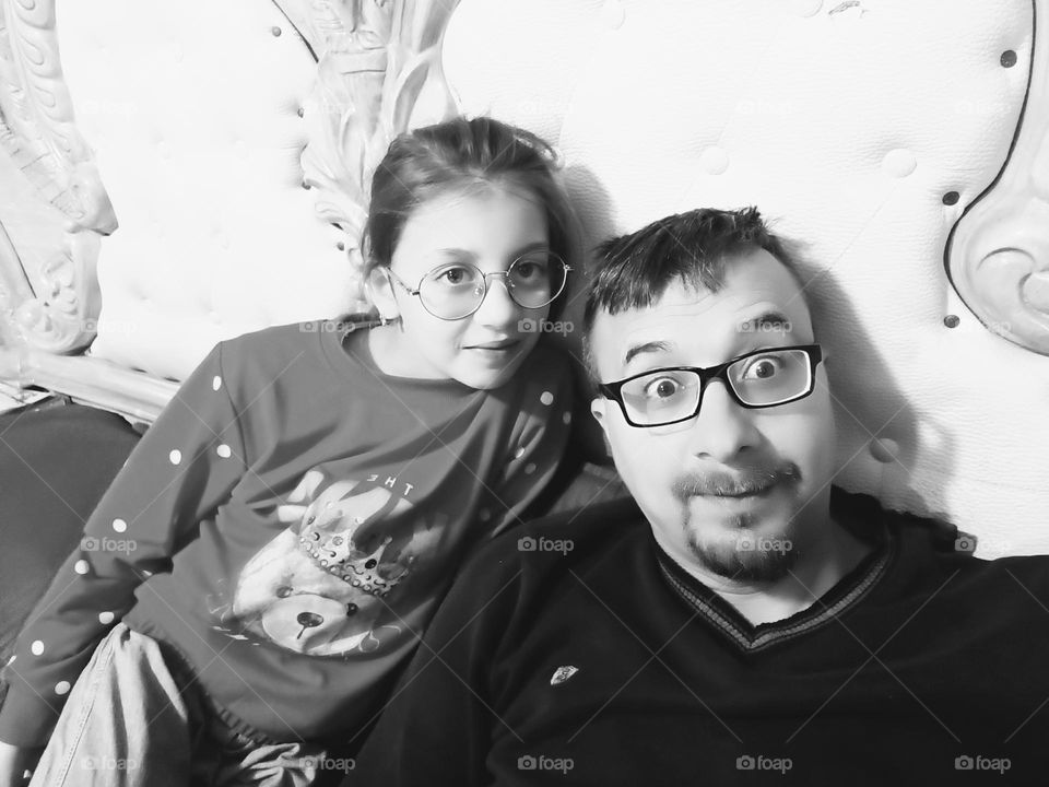 A cherished moment captured as you and your father share a seat on the sofa, embodying the warmth and connection found in the bond between family members