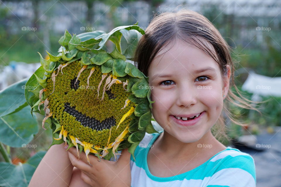 Smiling girl with smiling sunflower