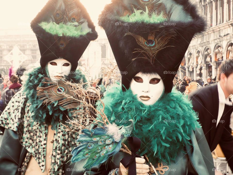 Green shades costumes and masks at Venice carnival in Italy 