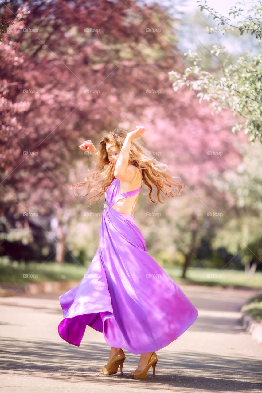 Beautiful young woman in a blossom park 