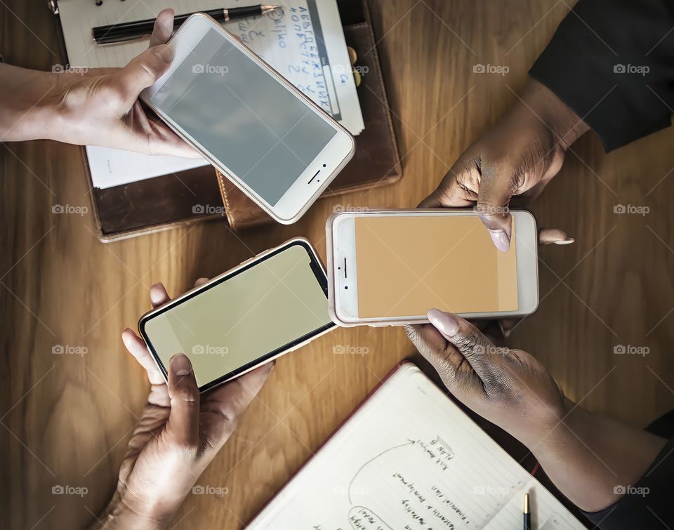 Close up of group holding mobile phones - three devices
Close up of people touching mobile phone screens