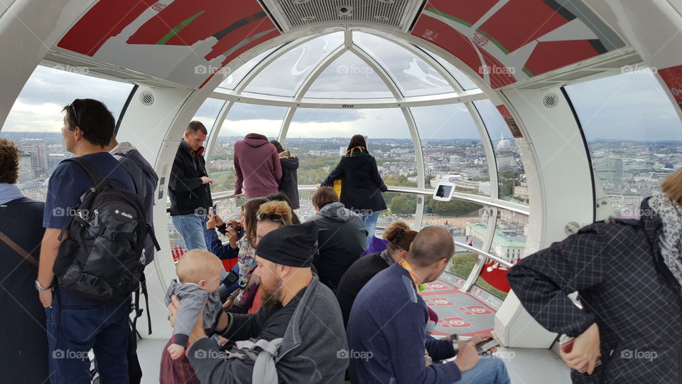 Tourists in London Eye capsule enjoying the city from above