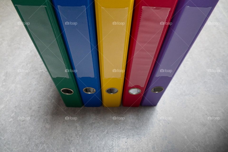 Folders of different colors stacked side by side.