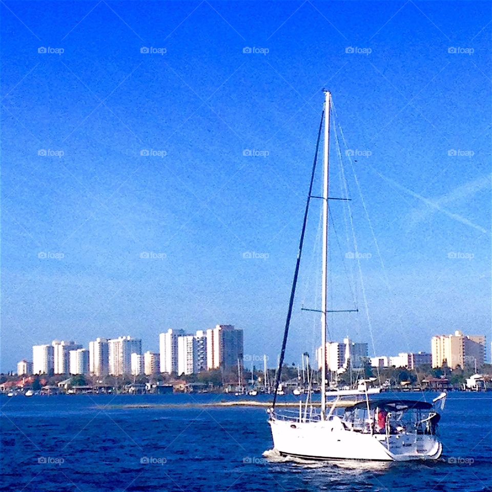 Sailboat cruising in after a day at sea. Observing from a fishing dock under a bridge in Cocoa Beach, FL