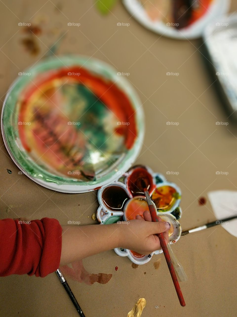 Little students painting Fall leaves