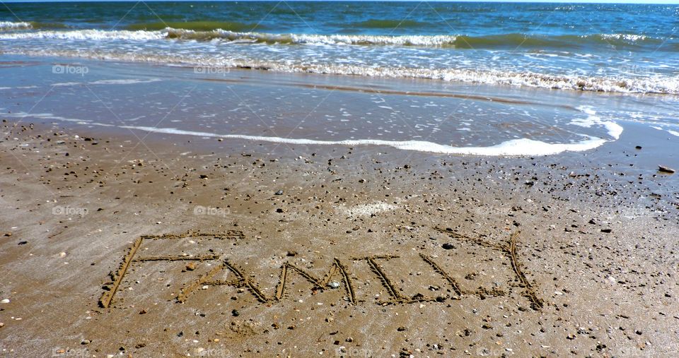 We are family!. Family written in the sand