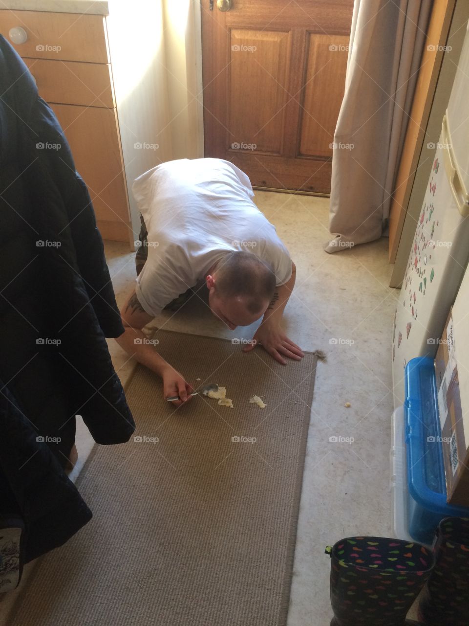Man eating trifle off the floor. 