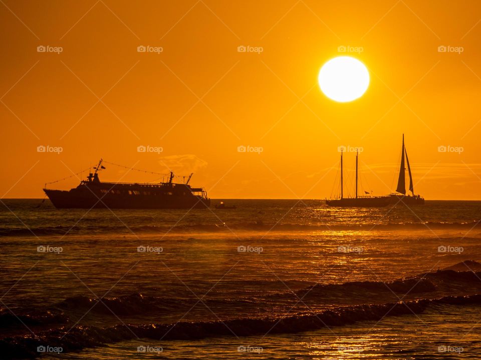 The late afternoon sun of mid June bakes the tropical environment of the Hawaiian island of Maui as ships cruise just offshore