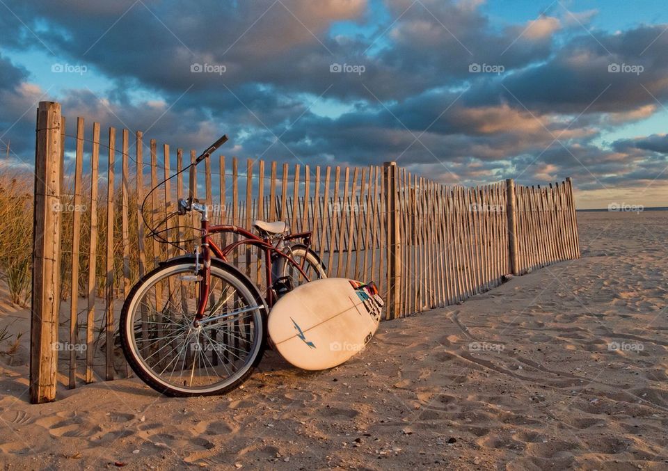 Bicycle and surfboard on the beach