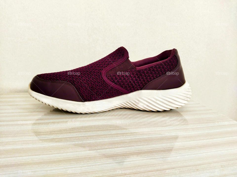 purple shoe with reflection on the table , white background