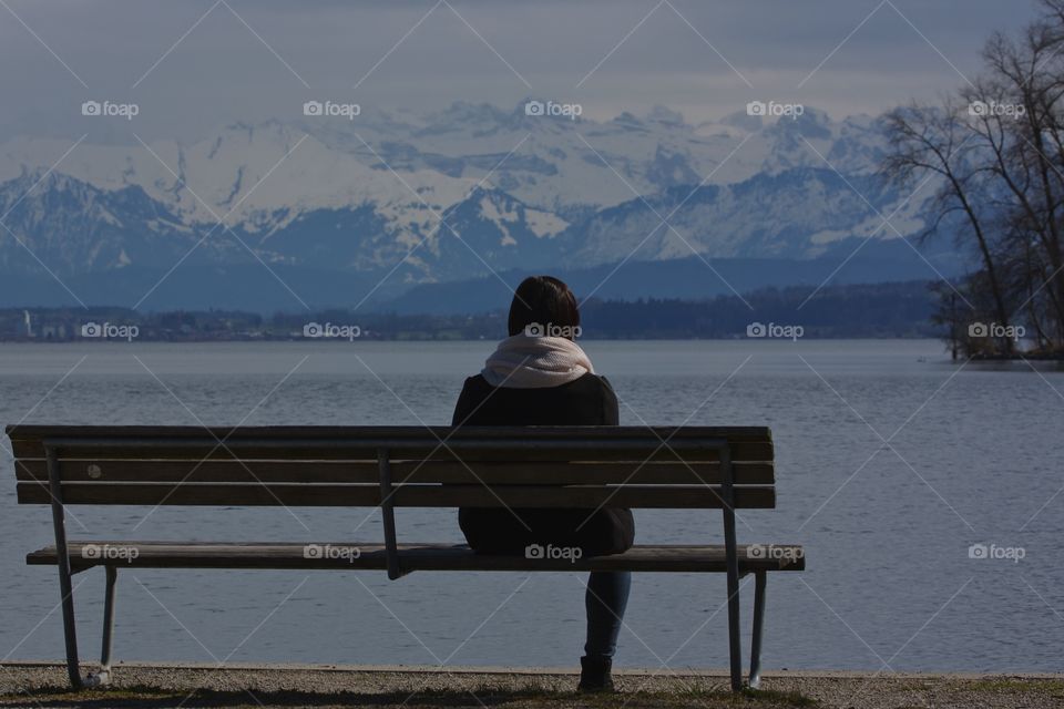 Young Lonely Girl Sitting By Lake Shore