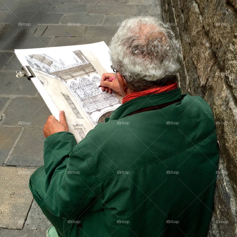 Elderly man drawing on the street
