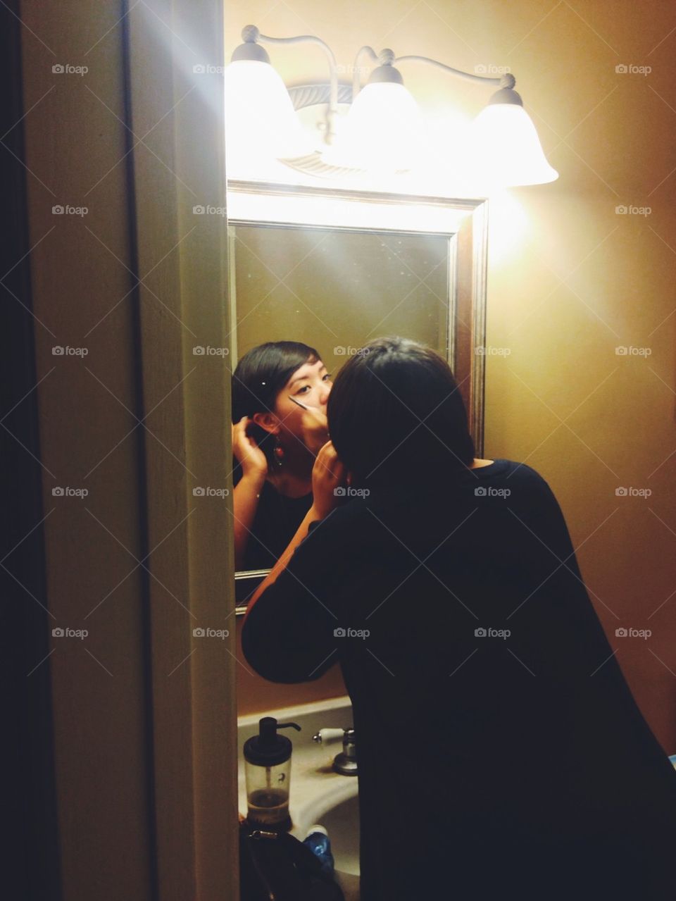 Woman putting on eyeliner