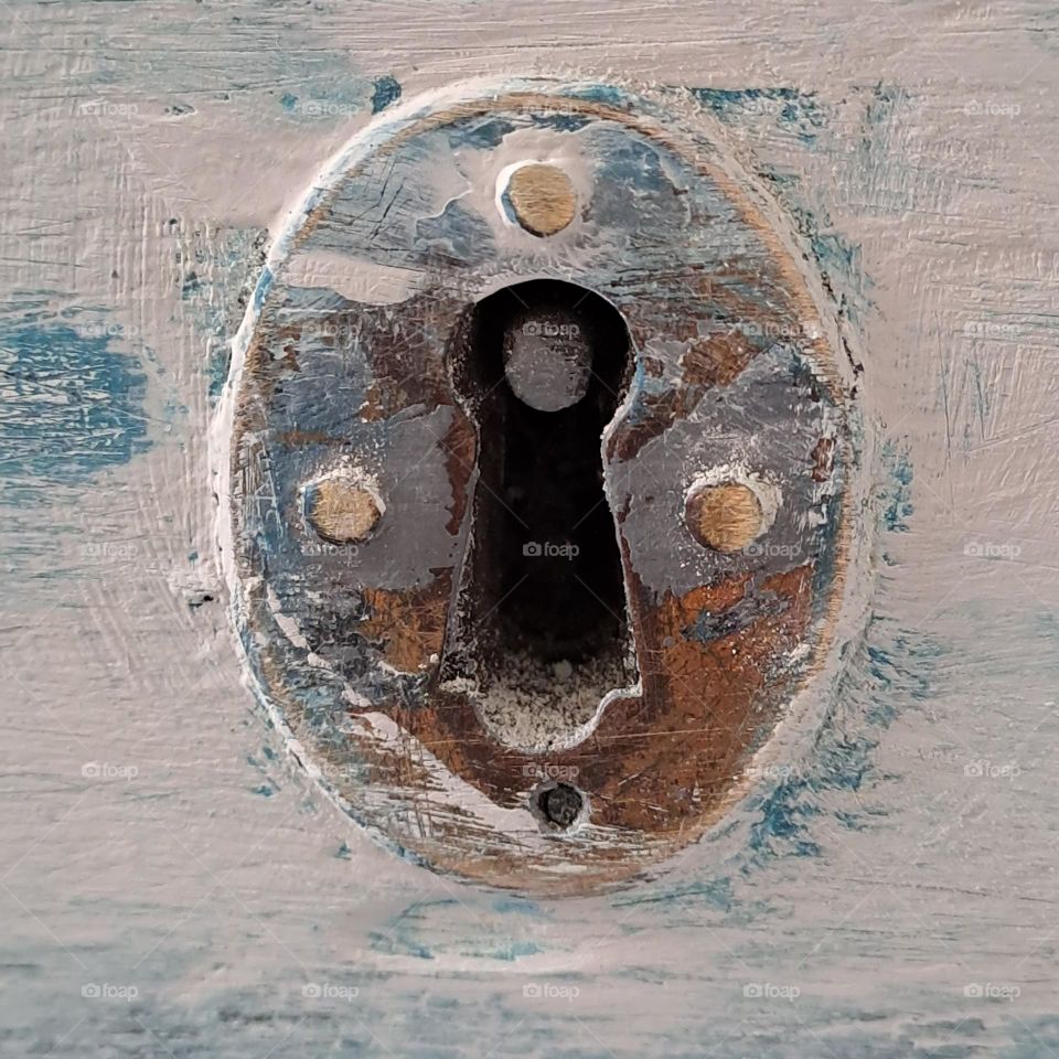 closeup keyhole lock distressed painted white and blue