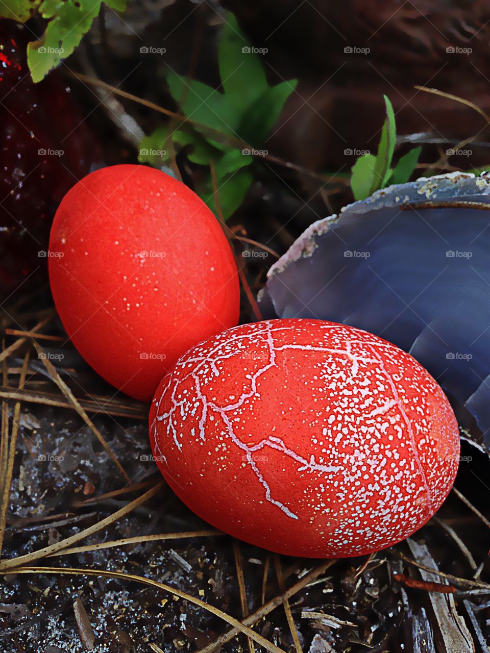 Brightly colored orange dyed eggs and a blue agate rock.