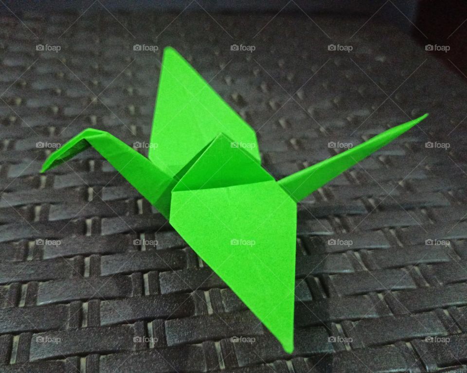 Green paper bird on table