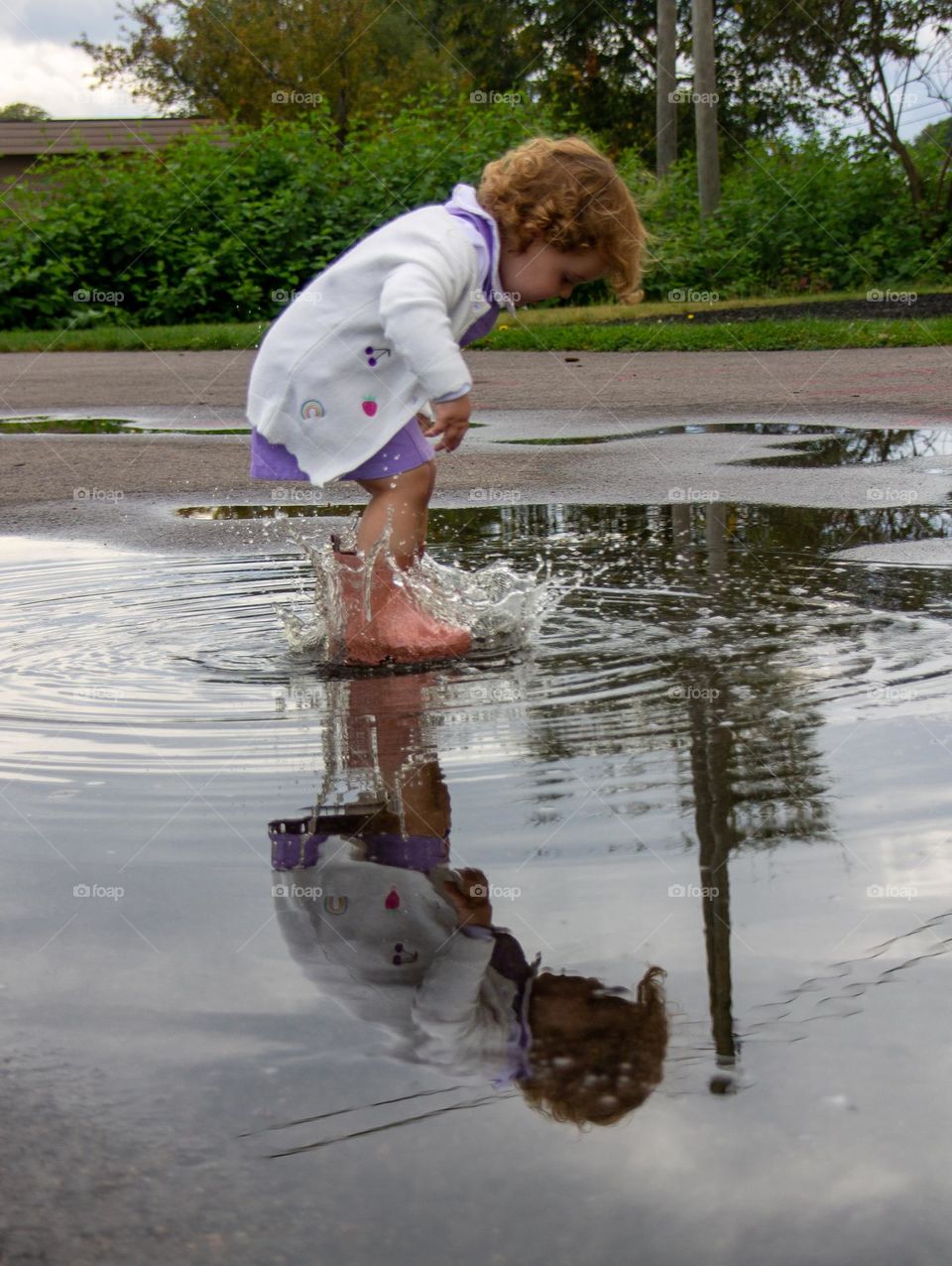 Little Kid plays in the waterpond.
She sees herself in the water reflection, that is awesome .